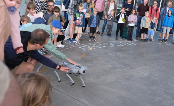 Mennesker danner en ring om en robot hund